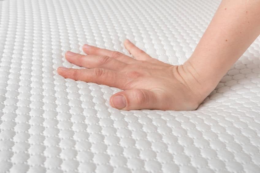 main qui appuie sur le matelas